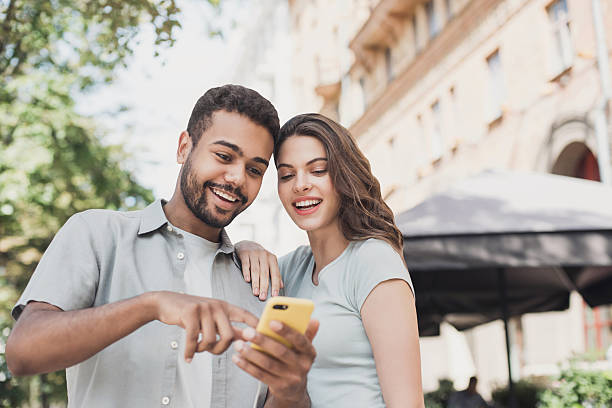 istock Beautiful happy couple using smartphone in a city 2220871936