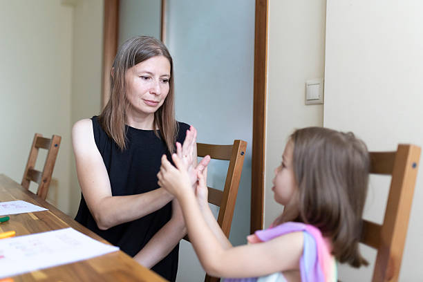 istock Mother and daughter playing hand clapping game at home 2220872279