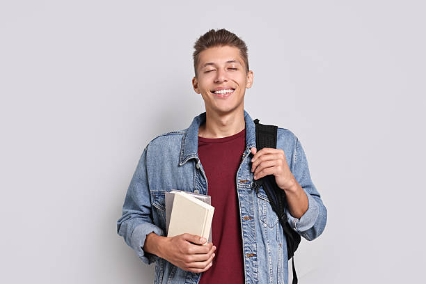 istock Happy student with backpack and books on grey background 2220872754