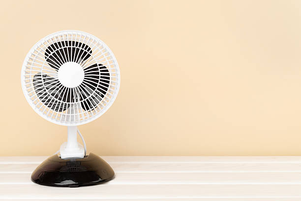 istock Electric fan on wooden background 2220874412