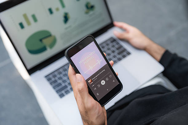 istock Young man smiling at his smartphone while listening to mindfulness podcast 2220874924