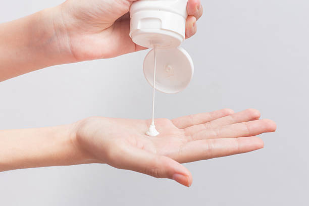 istock Woman pouring cream on hand with white background 2220877004