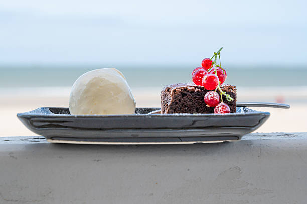 A delightful plate holds a brownie topped with creamy ice cream