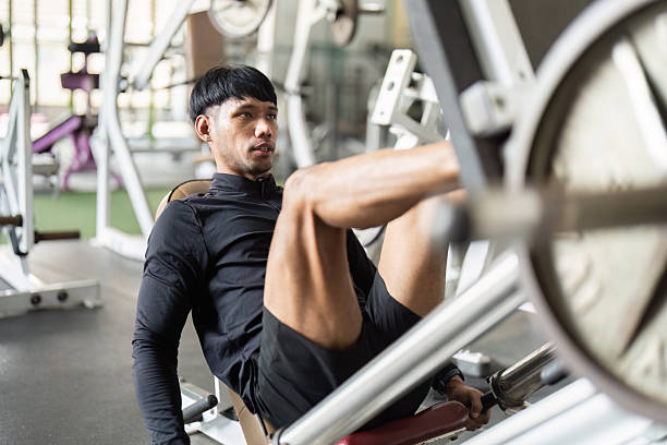 istock Leg Press Workout. Young man focusing on leg press exercise in a gym. 2220884997