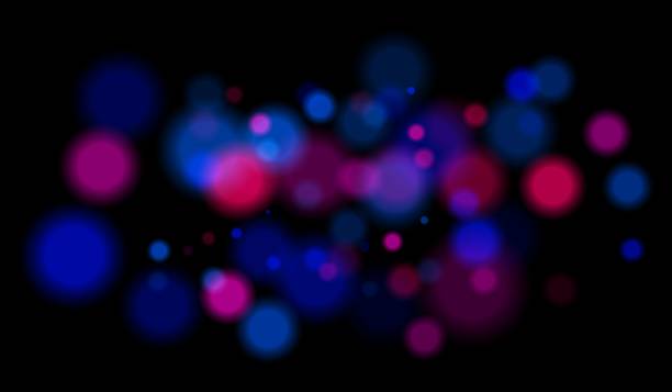 istock Multicolored blurred bokeh particles with violet, blue, pink hues floating on black background, creating festive or dreamy abstract composition. 2220885438