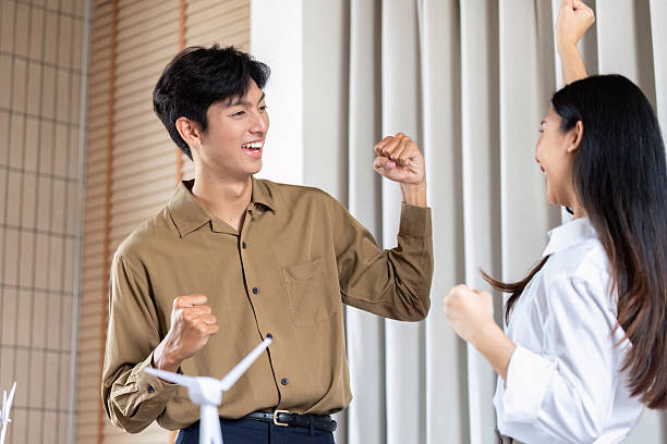 istock Sustainable teamwork celebrating success in renewable energy project 2220885937