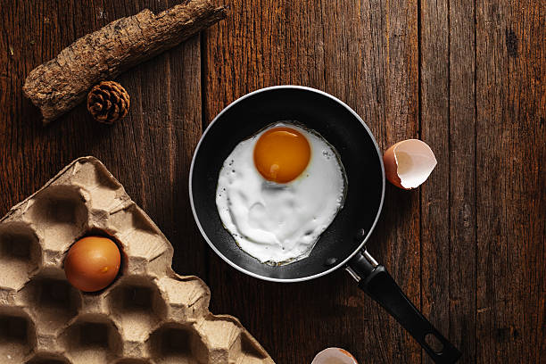 istock Fresh Raw Egg Cracked in Frying Pan on Rustic Wooden Surface 2220887601