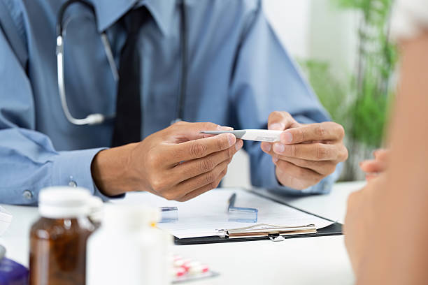 istock Thermometer Check. Doctor examining patient's temperature during consultation. 2220887818