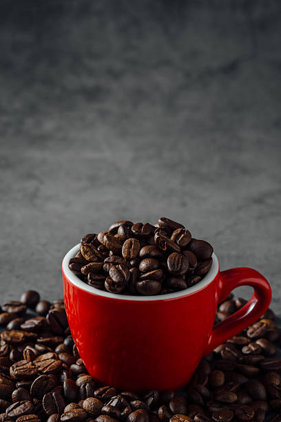 Red Cup Filled with Coffee Beans on Dark Textured Background
