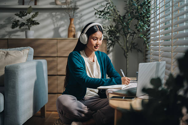 istock Woman enjoying her online class, attentively taking notes as she stays engaged and focused 2220890463