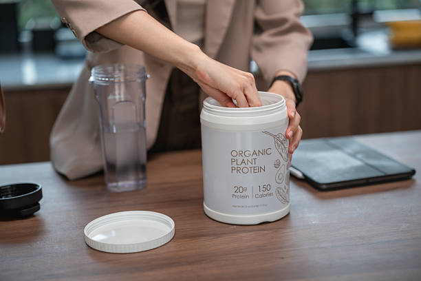 Businesswoman preparing a protein shake in her kitchen before heading to work, fueling her body with a nutritious boost to start her productive day