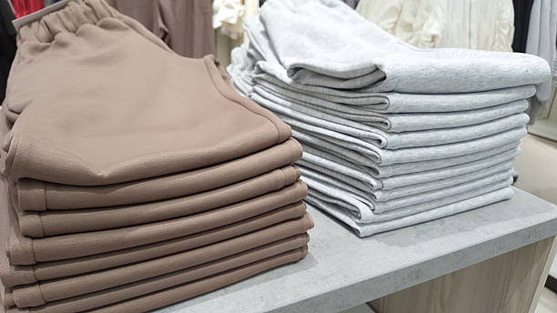istock Neatly folded brown and gray sweatpants in retail store display 2220893595