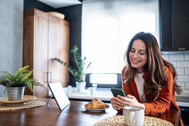 istock Young woman enjoying breakfast and social media in modern kitchen 2220896830