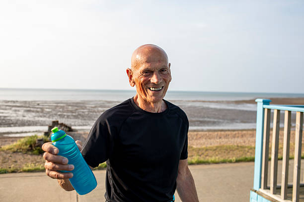 istock Cheerful active senior man with a water bottle by the coast 2220898262