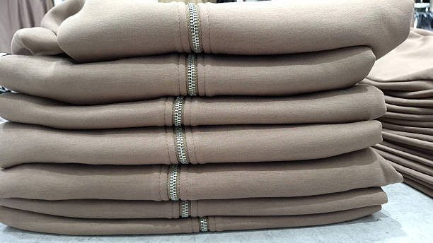 Stack of beige folded clothes with zippers on display