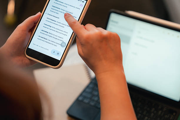 istock Close-up of a college student focused on her smartphone, using a modern AI app to help with her studies 2220899042