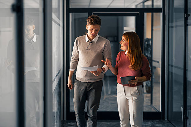istock Professional Interaction Between Colleagues in a Modern Workplace Hallway 2220899339