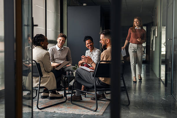 Group of Professionals Seated and Chatting in a Modern Office Setting