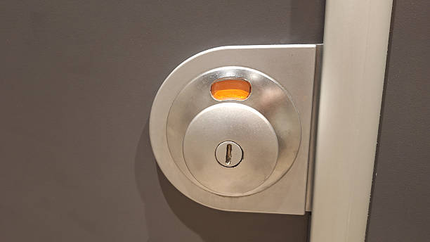 istock Secure metallic door lock mechanism with keyhole on gray surface 2220901762
