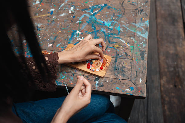 Gen Z designing and handcrafting beaded bracelets at a local art workshop, promoting the therapeutic benefits of artistic expression and personal creativity. The workshop offers a calming environment that fosters relaxation, meaningful connections, and support for the local community