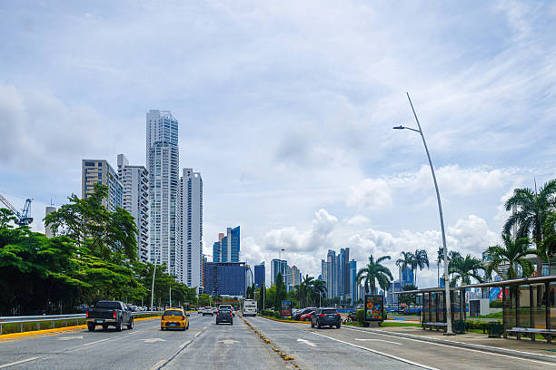 Panama City, Panama - June 12, 2025: Cars driving in a city avenue with cityscape of the modern downtown in the distance. Point of view image