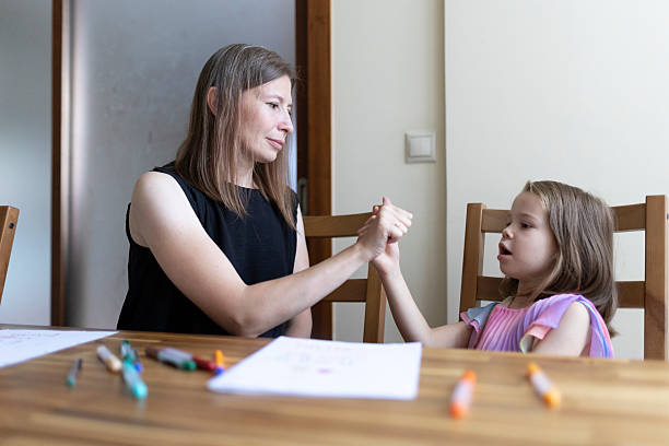 istock Speech therapist practicing exercises with a little girl during a session at home 2220909095