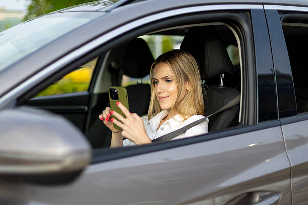 istock Businesswoman using smartphone while sitting in car 2220910449