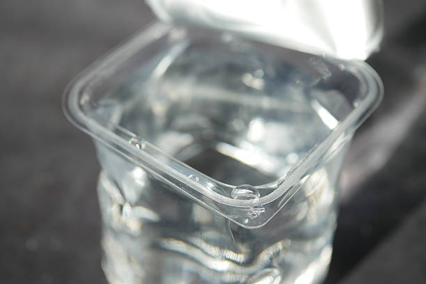 istock Clear container filled with water on a dark surface in daylight 2220910612
