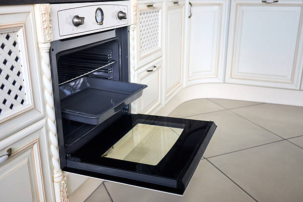 istock New modern electric oven built in black with counters and controls convention and grill, empty and opened. Telescopic guides. Classic style in beige kitchen. 2220915431