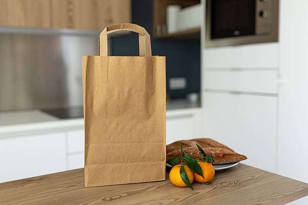 istock Paper bag on wooden table in kitchen, space for text 2220918997
