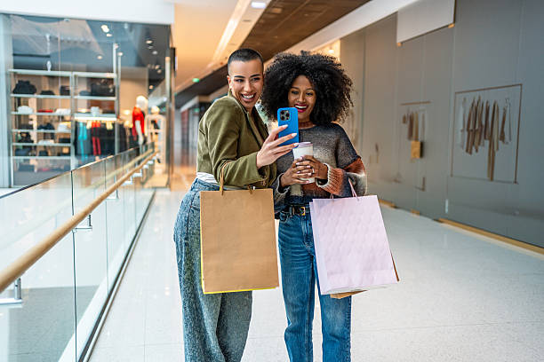 istock Two smiling women taking selfie while shopping in mall 2220926856