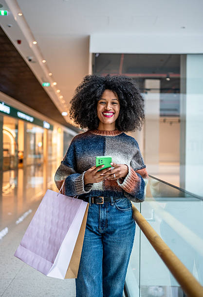 istock Young woman using phone while shopping at the mall 2220927738