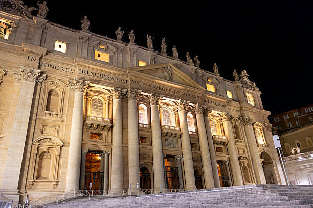 The majestic St. Peter’s Basilica shines under the night sky in Vatican City, surrounded by visitors in awe of its beauty