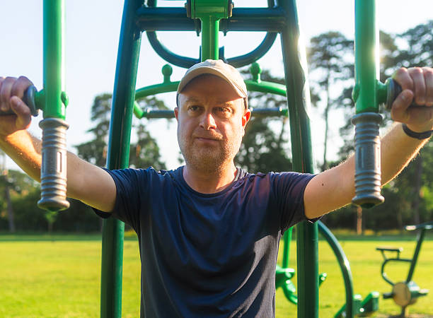 istock Mid adult man using chest press at outdoors gym 2220929446
