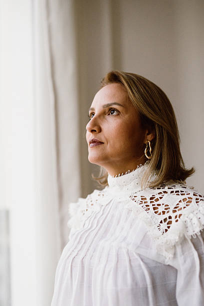 Woman looking out the window with thoughtful expression