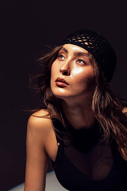istock Elegant Asian model in striking black outfit with dramatic lighting engagement 2220937132