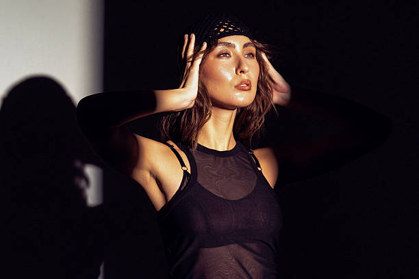 istock Stunning model poses dramatically with hands on head against a contrasting dark background 2220937813