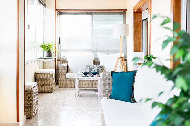 istock Interior terrace with light wicker sofas and white cushions, lots of light and plants 2220938132
