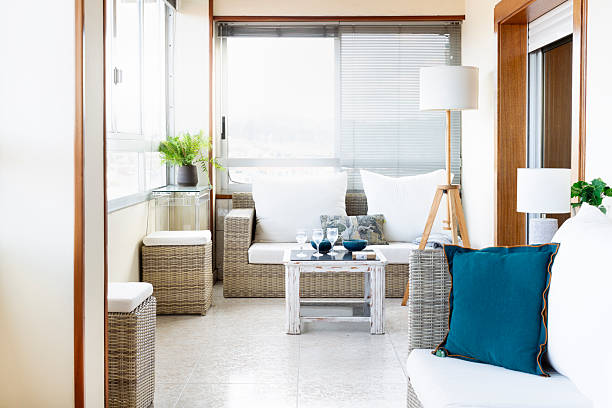 istock Interior terrace with light wicker sofas and white cushions, lots of light and plants 2220938136