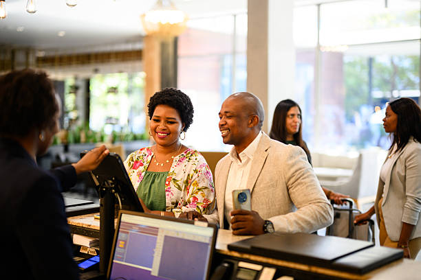 istock Happy couple checking in at hotel reception desk with friendly interaction and modern decor 2220940356