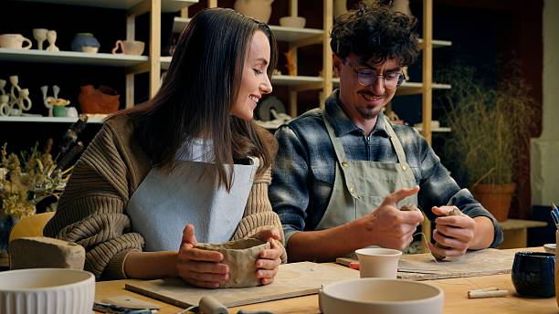 istock Happy woman man in pottery workshop creating handmade clay modeling class teacher student craft hobby sculpture couple date family potter artisan handcrafting ceramics have fun laughing in art studio 2220943978