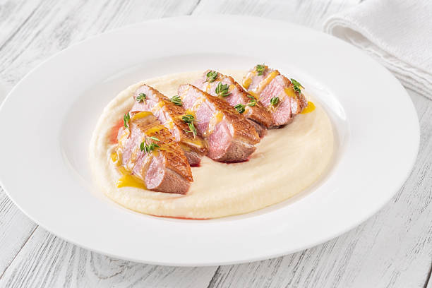 Sliced Duck Breast with Sauce and Thyme on Mashed Potato Bed