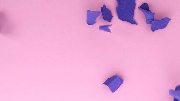 istock blue torn papers fall on the pink surface of the table 2220945068