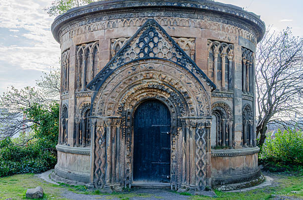 Horizontal wide angle shot of the Dryburgh Abbey Chapel, an arched room made of stone with five windows, illuminated by morning light.