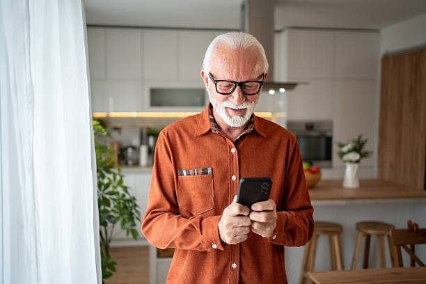 istock Senior man using smartphone at home, enjoying modern technology 2220950661
