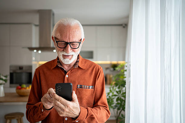 istock Senior man using smartphone at home: smiling and browsing the internet 2220950727