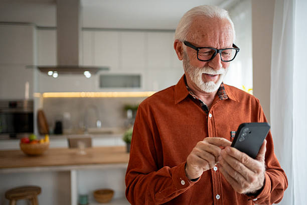 istock Senior man using smartphone at home, enjoying modern technology 2220950798