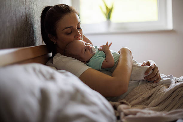 istock Mother kissing her sleeping baby 2220958713