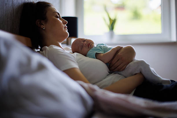 istock Exhausted mother and baby sleeping together 2220958724