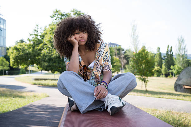 Portrait of an Afro Latina woman from Bogota, Colombia, between 40 and 44 years old, at home in a defiant attitude wearing her glasses and white shirt while she is alone at home.